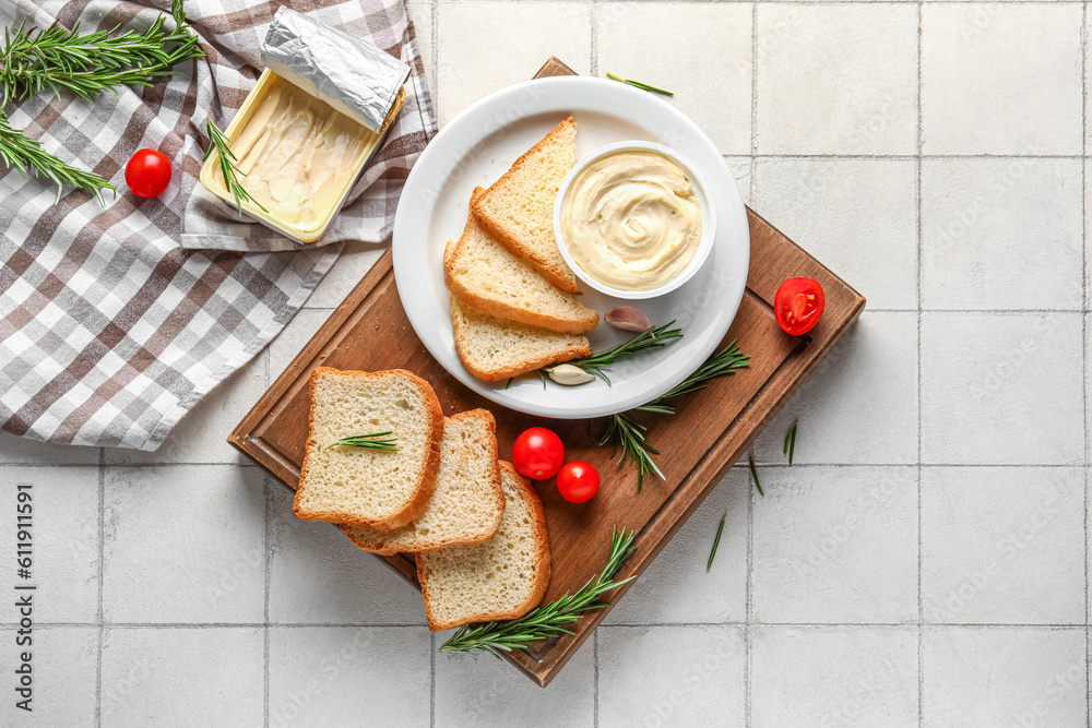 Wooden board with boxes of processed cheese, toasts and vegetables on white tile background