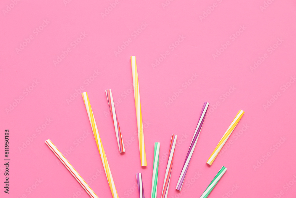 Different drinking straws on pink background