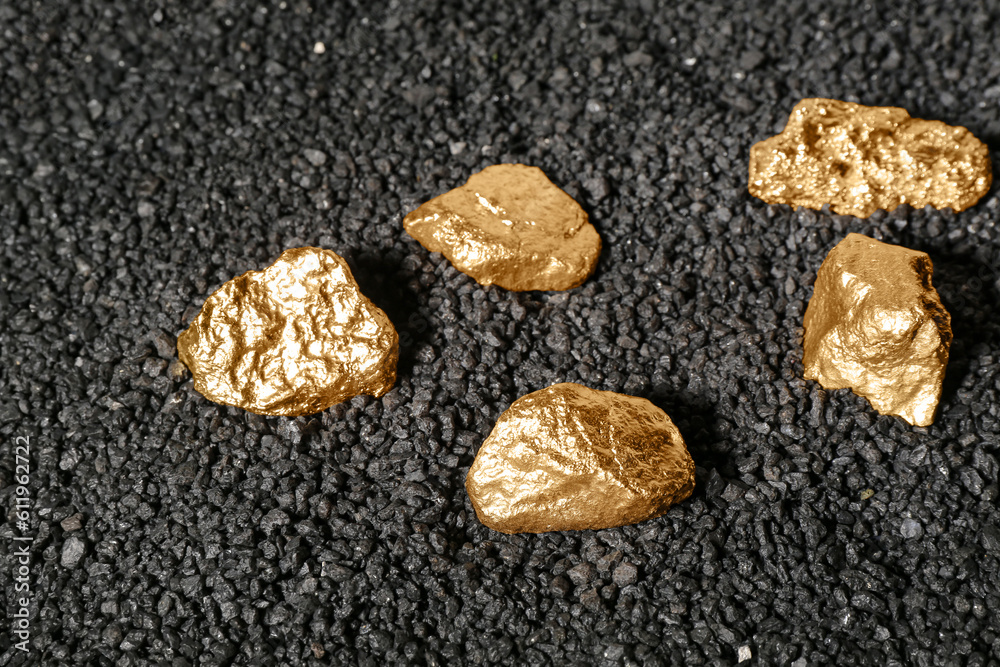Golden nuggets on black coal, closeup