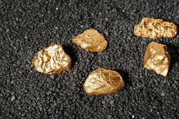 Wall Mural - Golden nuggets on black coal, closeup