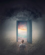 © psychoshadow - Teleportation door to your hidden dreams. A person in a dark land in front of a doorway as portal leading to a tropical beach with blue sea and sunset view. Magical and surreal scene, travel concept