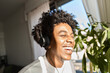 © insta_photos - Happy funky gen z hipster African American guy wearing headphones laughing at home, listening music, having fun feeling relaxed standing in living room at home. Close up authentic shot.