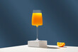 Glass of 100% Orange juice with orange slices. Glass of drink with slices of fresh orange against bright blue background. Modern still life with citrus fruits. Copy space
