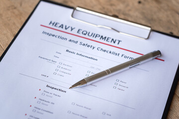 Wall Mural - a ballpoint pen is placed on heavy equipment inspection and checklist form. industrial safety workin