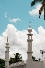 Wall Mural - Beautiful mosque minaret image with cloudy blue sky on the background, Eid Mubarak background