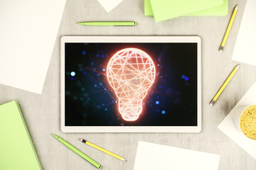 Poster - Creative light bulb hologram on modern digital tablet screen, idea concept. Top view. 3D Rendering