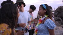Group Of Multiracial Friends Gathering Outdoors During A Beach Party Speaking And Laughing Together. People Enjoying Summertime.