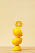 A pyramid of juicy yellow lemons on a beige background. Creative concept of fruits, citrus fruits. 