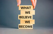 © Dzmitry - We become or believe symbol. Concept word What we believe We become on wooden block. Beautiful grey table grey background. Businessman hand. Business we become or believe concept. Copy space.