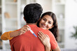 © Prostock-studio - Happy indian woman holding positive pregnancy test and hugging her husband