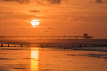 Sunrise At The Beach With Fishing Pier And Sea Birds Flying