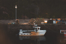 Moody, Atmospheric Golden Light On A Fishing Boat Moored At Crail Harbour, An Historic Seaside Fishing Village On The Coast Of Fife, Scotland, UK.