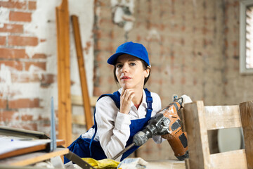 Wall Mural - Woman contractor with industrial puncher at construction site