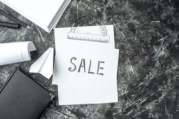 Wall Mural - top view of white sheet with sale writing and notebook ruler pens blanks paper plane on gray distres