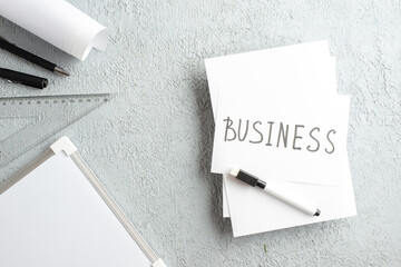 Wall Mural - top view of business writing on white sheet pens ruler desk blank on gray sand background