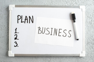 Wall Mural - top view of plan and numbers on white desk business writing marker on white sheet on gray sand backg