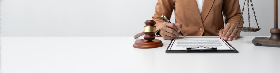 Lawyer or legal advisor signing a contract with a pen and verifying the details of the recorded information. justice concept. Copy space, panorama, banner