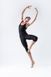 © danmorgan12 - Professional Male Ballet Dancer Man in Black Dance Suit Tights Posing in Lifted Ballanced Dance Pose With Hands Circled in Studio.