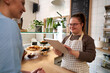 © Westend61 - Happy cafe owner with down syndrome taking order of customer through tablet PC