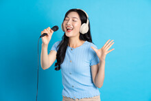 Portrait Of Smiling Asian Woman Posing On Blue Background
