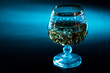 glass of whiskey with ice and warm light on a black table with reflection and warm atmosphere. not moderate alcohol consumption