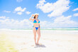 © photok - 真夏の海と帽子をかぶった青い水着の白人少女（全身）