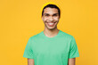 © ViDi Studio - Young smiling happy fun cool cheerful man of African American ethnicity he wears casual clothes green t-shirt hat looking camera isolated on plain yellow background studio portrait. Lifestyle concept.