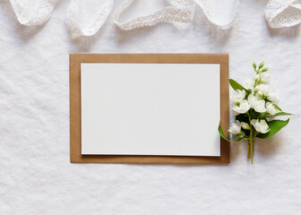 Sticker - Empty card mockup in minimalism floral decor on white textile background, Template for congratulations or invitations.