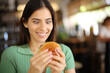 © PheelingsMedia - Glutton woman looking at burger in a bar