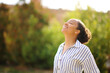 Happy black woman breathing fresh air in a park