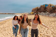 © bernardbodo - Four young women reunited together on beach.