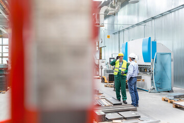 Engineer and worker talking in factory