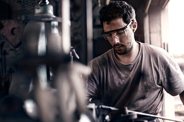 Focused blacksmith shaping iron in forge