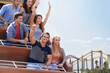 © KOTO - Portrait young man giving thumbs-up on amusement park ride