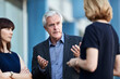 © KOTO - Senior businessman gesturing and talking to colleagues