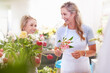 Laughing florists arranging bouquet in flower shop