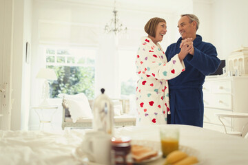 Wall Mural - Mature couple dancing in bathrobes in bedroom