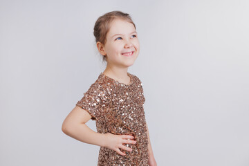 Wall Mural - Happy little girl in golden dress in studio