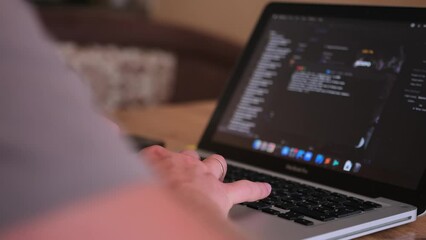 Male hands writing program codes on his computer screen close-up. IT specialist programmer work at home typing code on laptop. Freelancer and work at home concept. Remote work arrangements. 