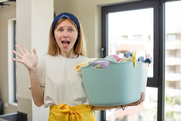 Wall Mural - young pretty woman feeling happy and astonished at something unbelievable. laundry and wash clothes concept