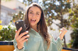 © kues1 - pretty woman feeling shocked,laughing and celebrating success. smartphone concept