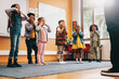© Jacob Lund - School children moving along to an educational song, kids participating in a class activity with their teacher