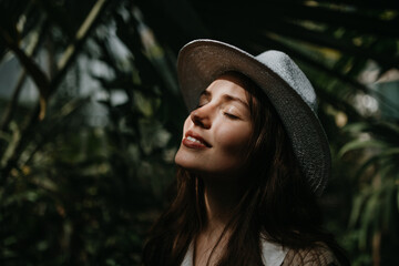 portrait of young woman with hat in botanical garden.