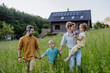 © Halfpoint - Happy family in front of their house with solar panels on the roof.