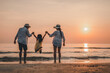 © Garun Studios - Happy Asian family jumping together on the beach on vacation.