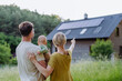 © Halfpoint - Rear view of family near their house with solar panels. Alternative energy, saving resources and sustainable lifestyle concept.