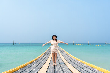 Wall Mural - Young asian woman standing on pontoon walkway in tropical sea