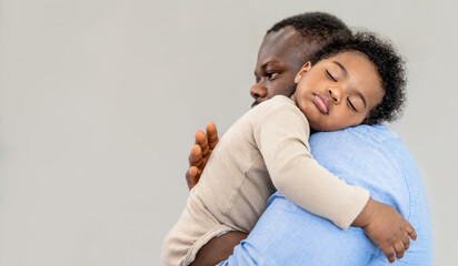 African family, Close up on face of Nigerian baby newborn son is 10-month-old, sleeping on father's shoulder with grey background, to baby newborn and African family concept.