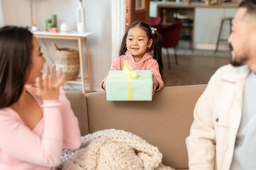 Wall Mural - Asian Girl Giving Gift To Parents Celebrating Holiday At Home