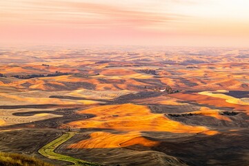 Sticker - Beautiful golden sunset over a harvested wheat field with a rolling hill surface